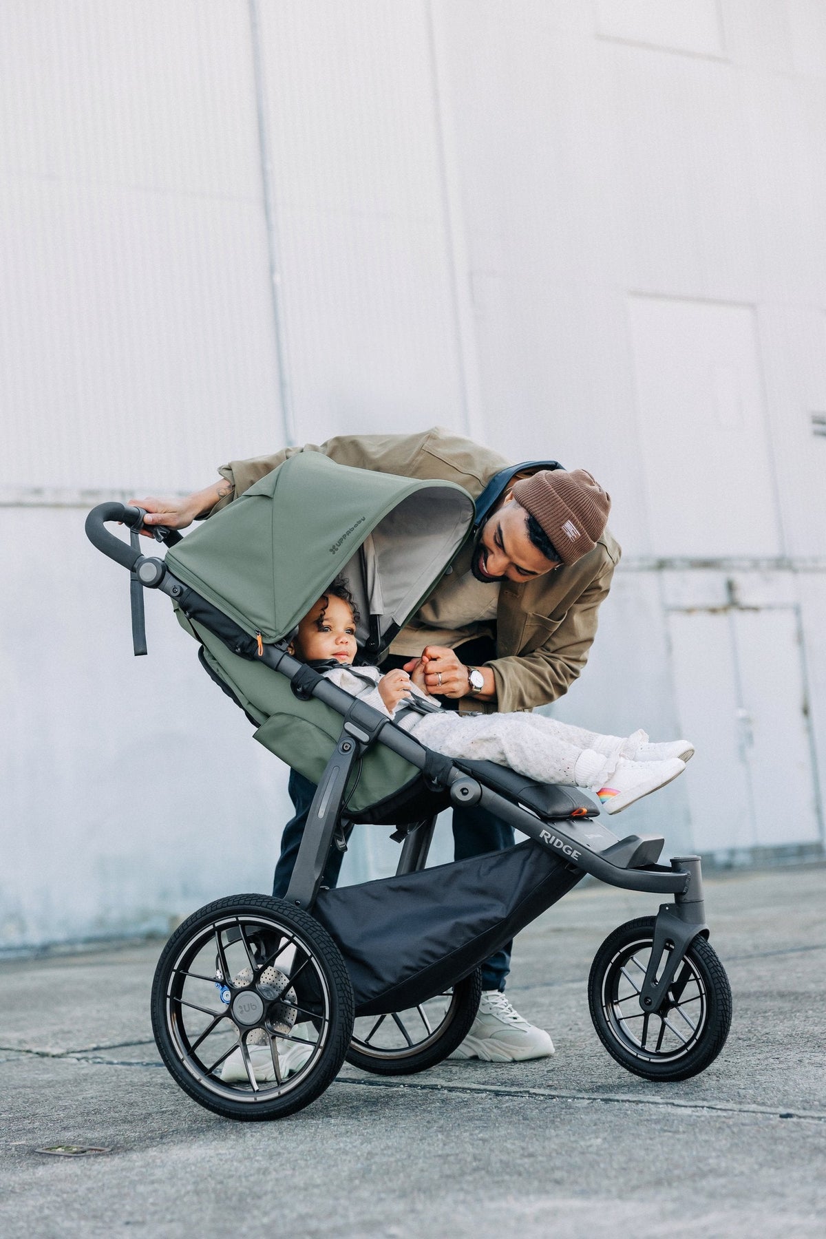 UPPAbaby Ridge V2 Pram Jogger in Evelyn (Meadow Green), checking on a child in the seat