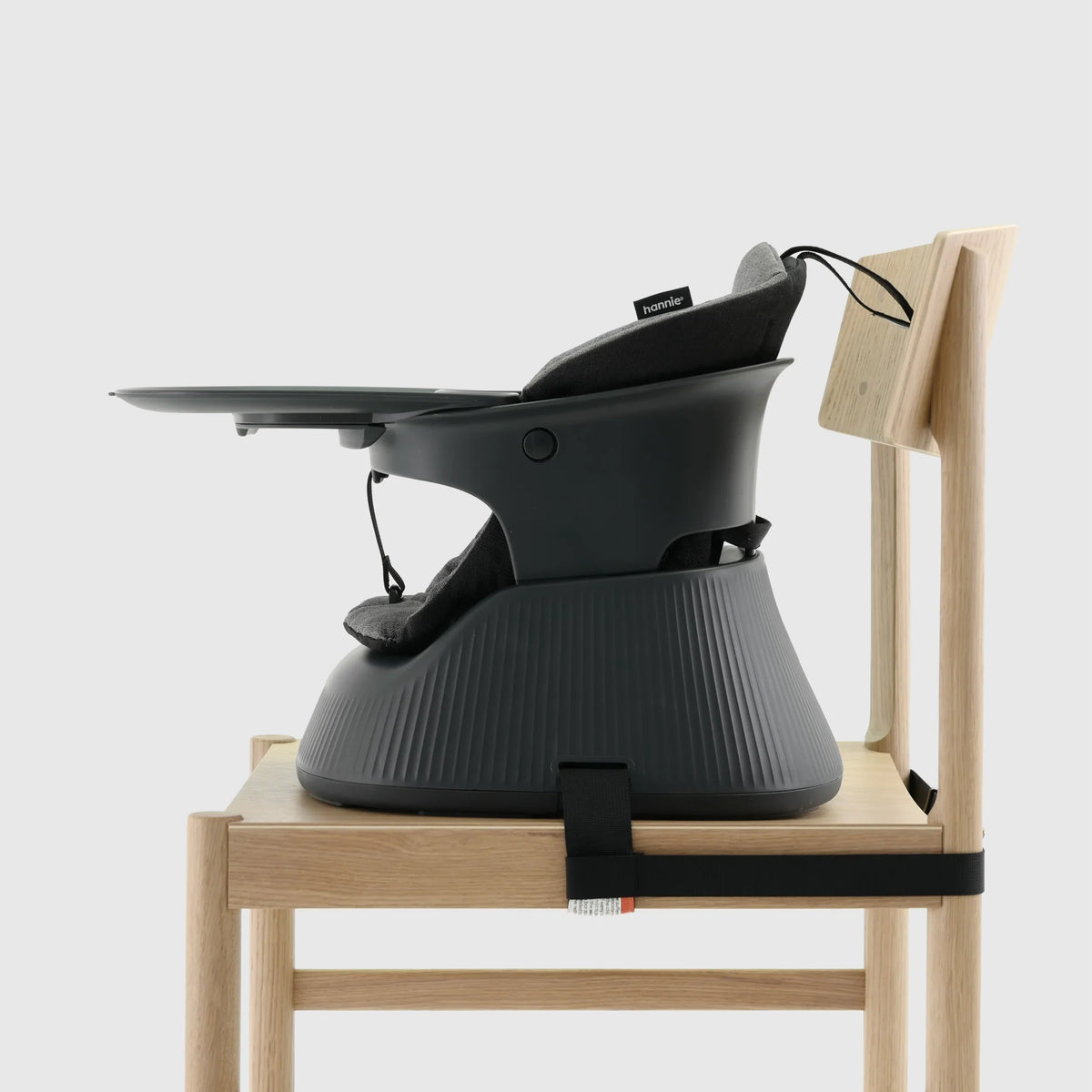 Hannie portable high chair in charcoal black, shown from the side view, lightweight and compact for easy use and transport.