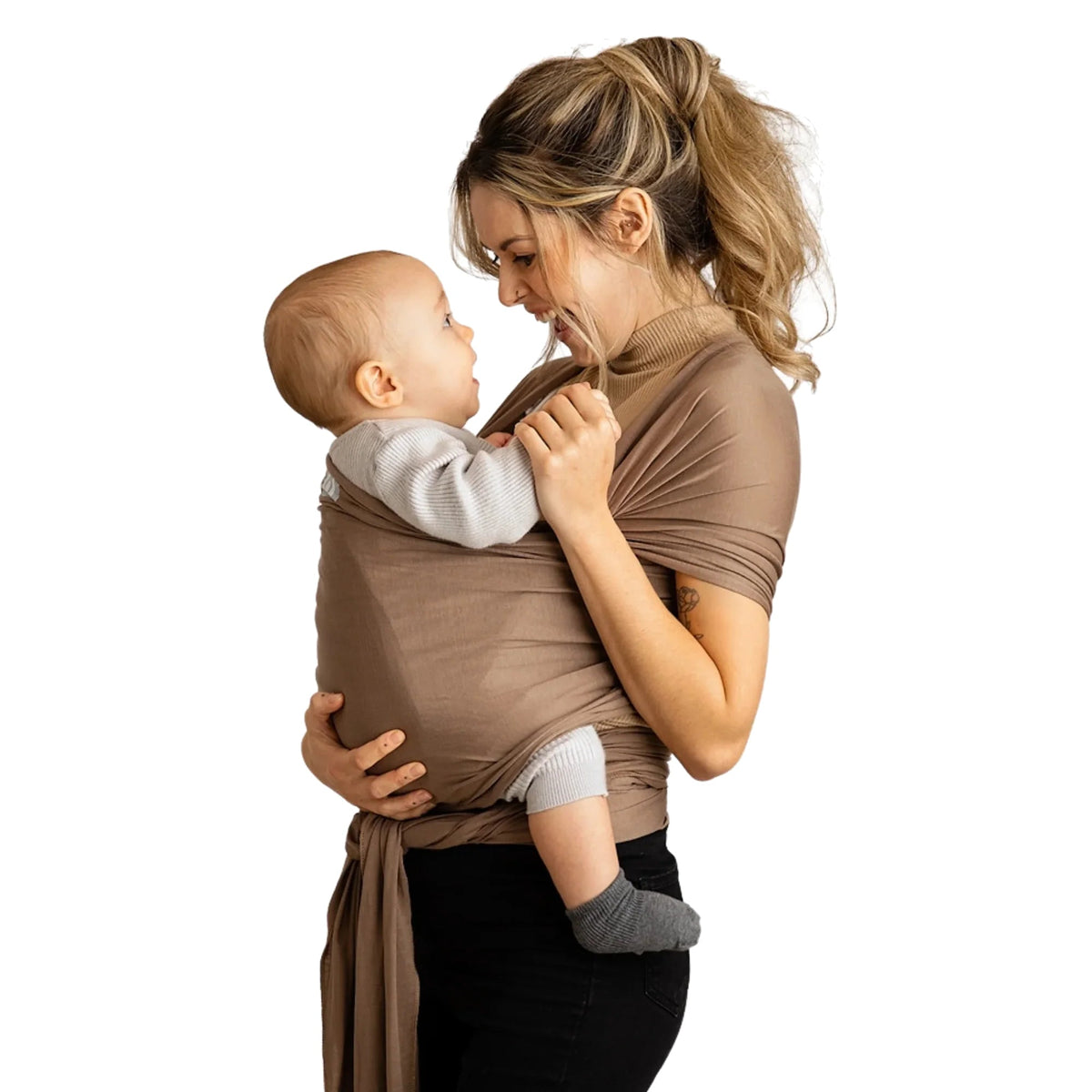 Gaia Baby stretchy baby wrap in nutmeg color, shown worn by a parent, made from soft, elastic fabric for comfortable baby carrying.