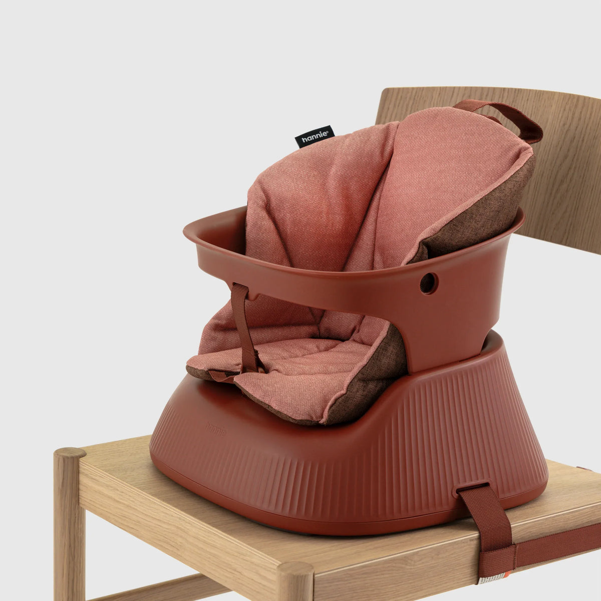 Hannie portable high chair in mahogany red with cushion, showcasing a sturdy design and compact frame for convenient seating.