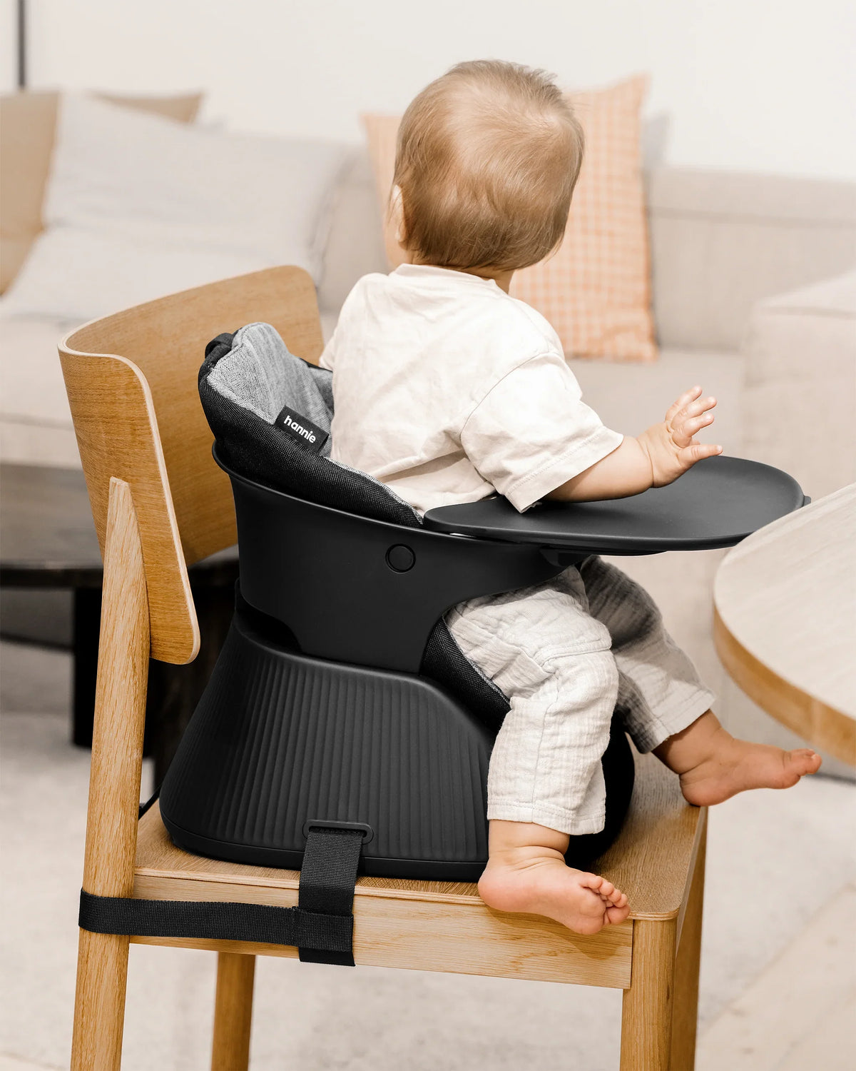 Hannie portable high chair in charcoal black, featuring a sturdy frame and comfortable seat for easy feeding and seating.