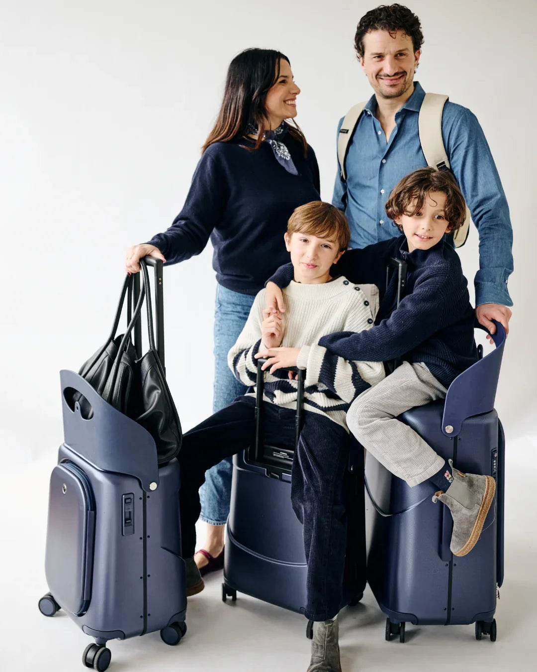 MiaMily Check in Plus navy blue suitcase with hard shell exterior, four spinner wheels, and extendable handle for travel.