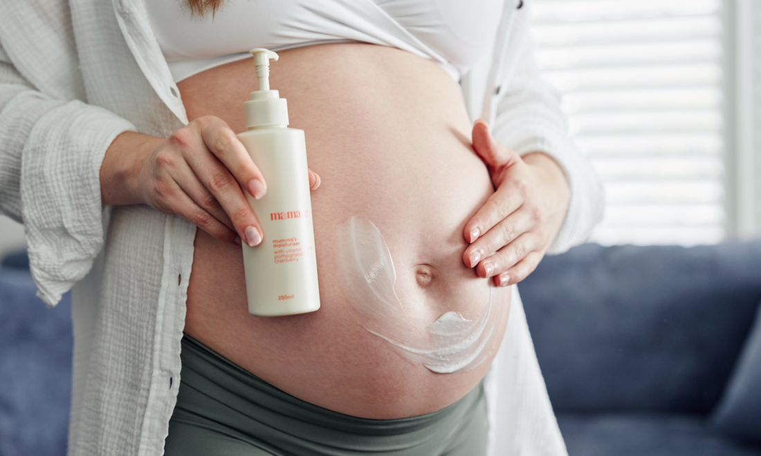 Pregnant woman applying body moisturiser as part of a simple pregnancy skincare routine