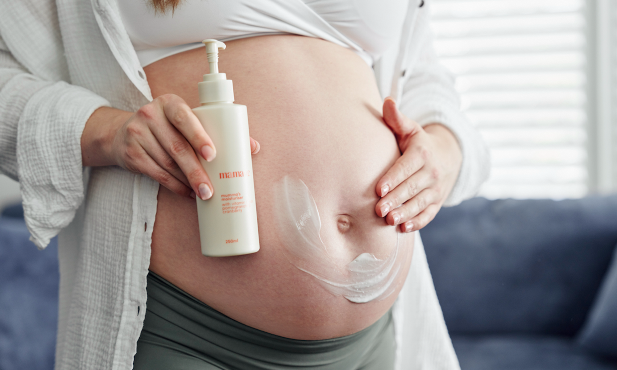 Pregnant woman applying body moisturiser as part of a simple pregnancy skincare routine