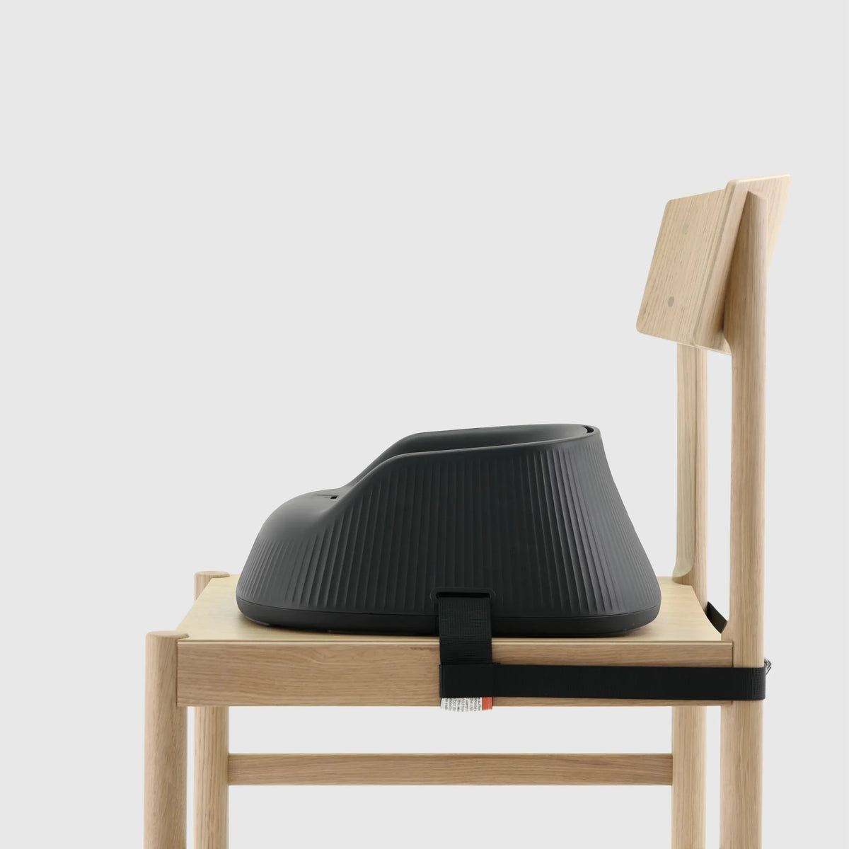 Hannie portable high chair in charcoal black, showing side view with adjustable seat and safety straps for infants and toddlers.
