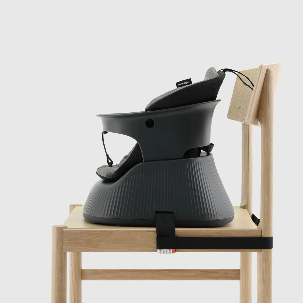 Hannie portable high chair in charcoal black, shown from the side with a sturdy design and adjustable features for comfortable seating.