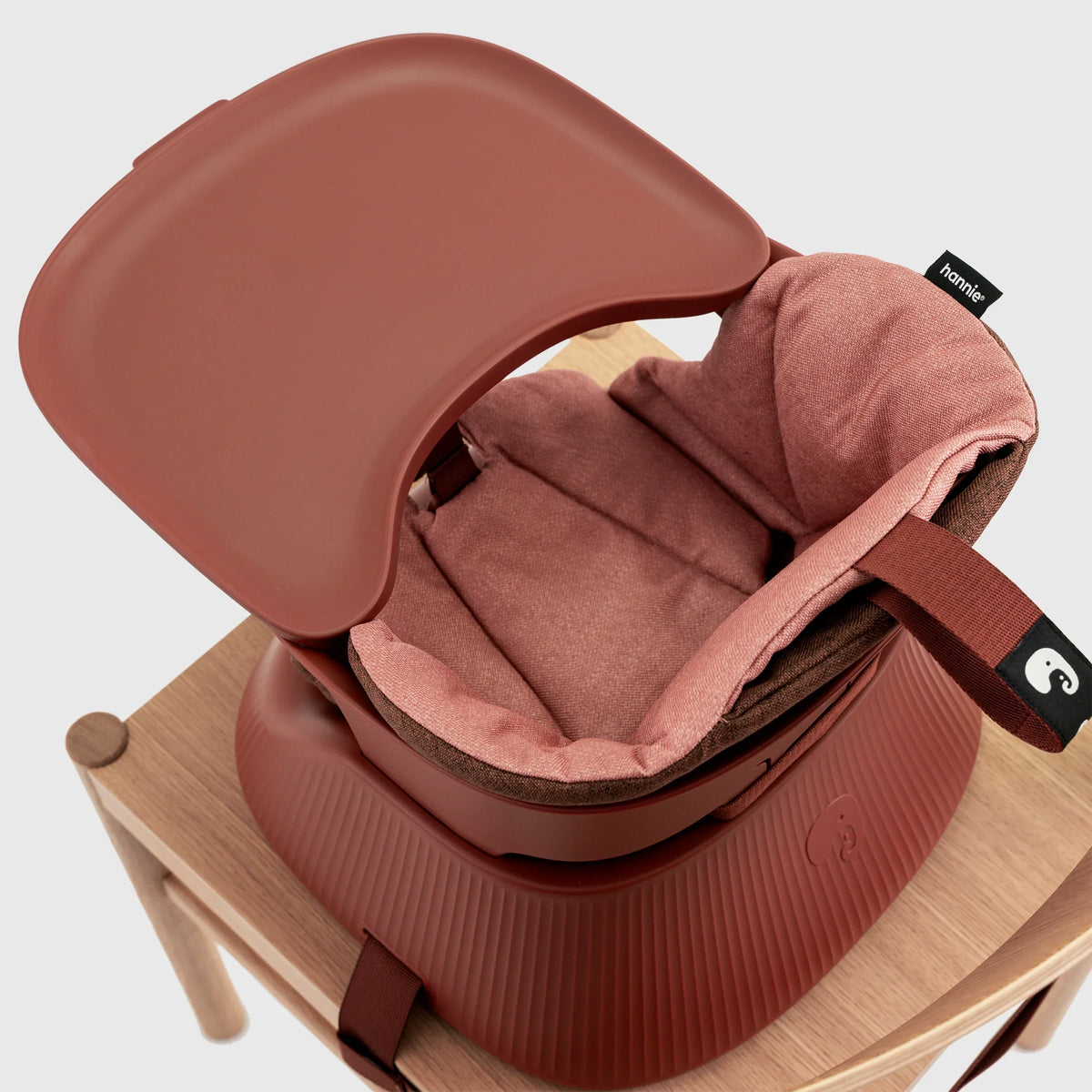 Hannie portable high chair in mahogany red with detailed close-up showing its sturdy design and smooth finish.