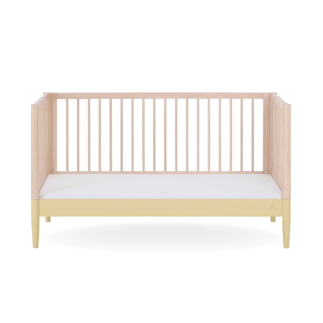 Gaia Baby Eos Cot Bed in natural ash finish with primrose yellow bedding, showcasing a modern wooden baby cot with a slatted design.