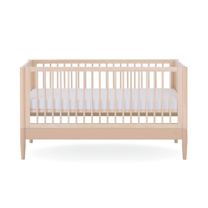 Gaia Baby Eos Cot Bed in natural ash with powder blush finish, showing a sturdy wooden frame and smooth pastel-colored accents.