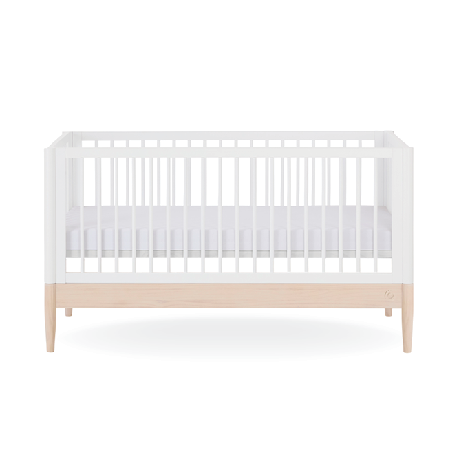 White Gaia Baby Eos Cot Bed with natural ash accents, showcasing a sturdy wooden frame and sleek, modern design.