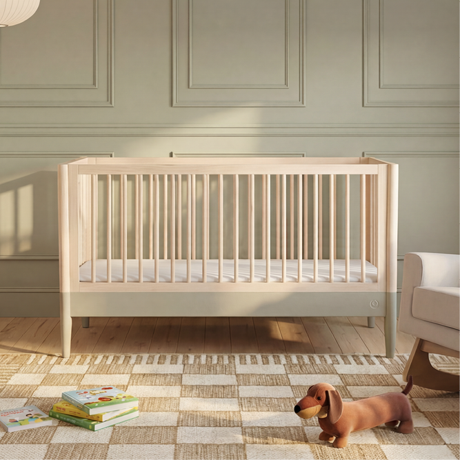 Natural Gaia Baby EOS cot bed in desert sage finish with slatted sides and sturdy wooden construction.
