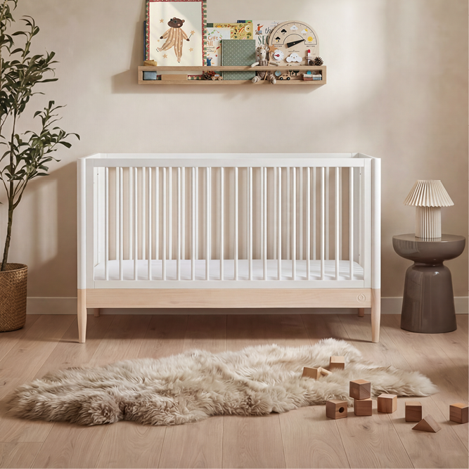 White Gaia Baby Eos cot bed with natural finish, featuring sturdy wooden construction and a classic design for a nursery.