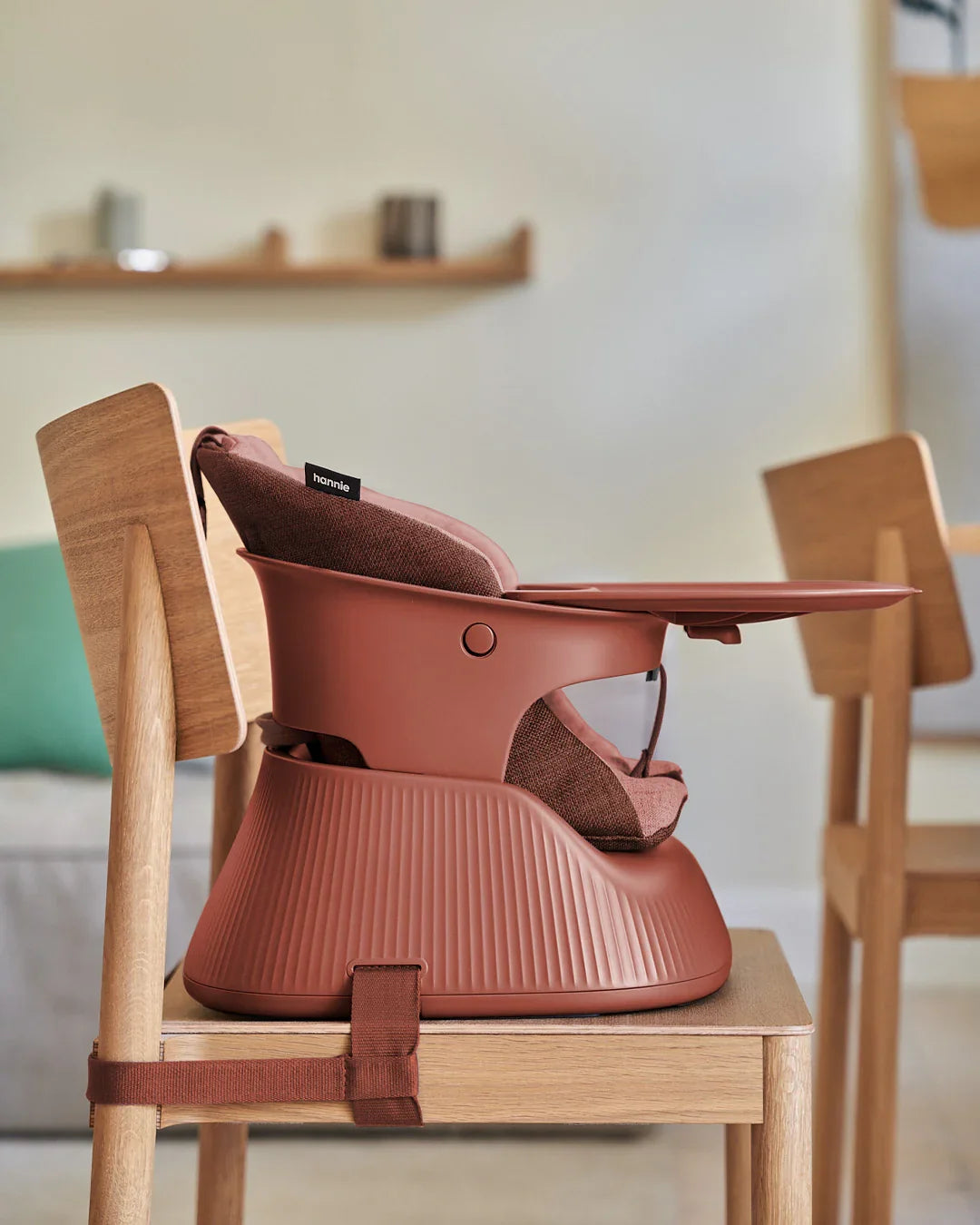 Hannie portable high chair in Mahogany Red with a sturdy frame and padded seat, suitable for feeding infants and toddlers.