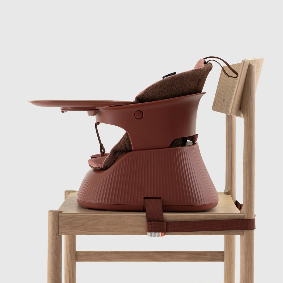 Hannie portable high chair in mahogany red, shown from the side with a sleek wooden design and sturdy frame.