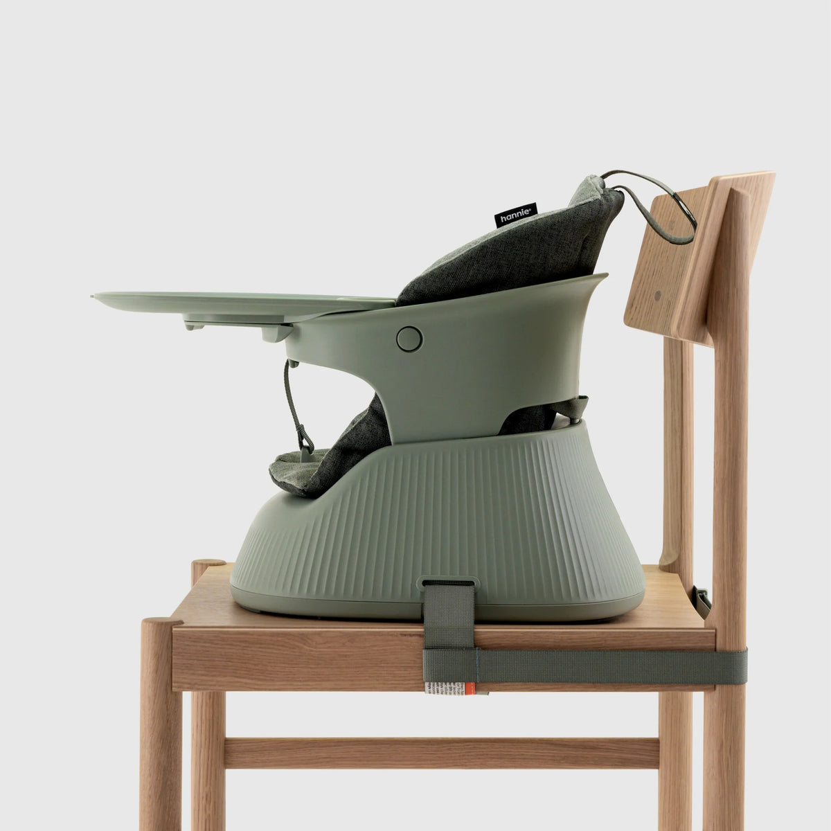 Hannie portable high chair in sage green, shown from the side with a compact, lightweight design perfect for on-the-go feeding.